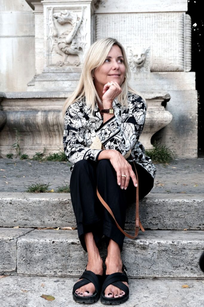 The Danish TV- correspondent, Eva Ravnbøl, sitting on stairs in Rome, awaiting our visit February 2024.